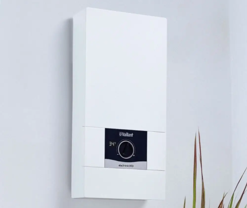 Weißer Elektro-Durchlauferhitzer von Vaillant an der Wand mit einem Temperaturregler, der auf 34°C eingestellt ist.